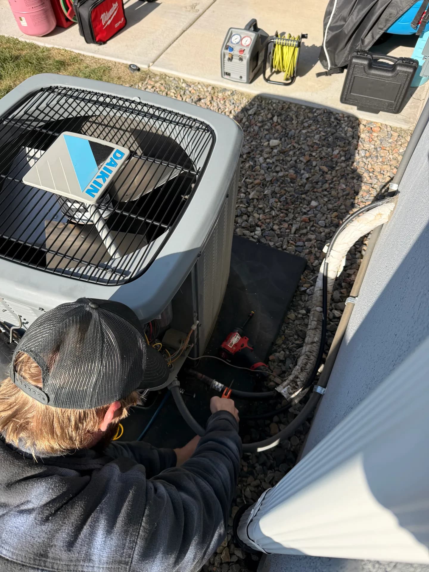 A technician repairing a Daikin condenser at a Utah home