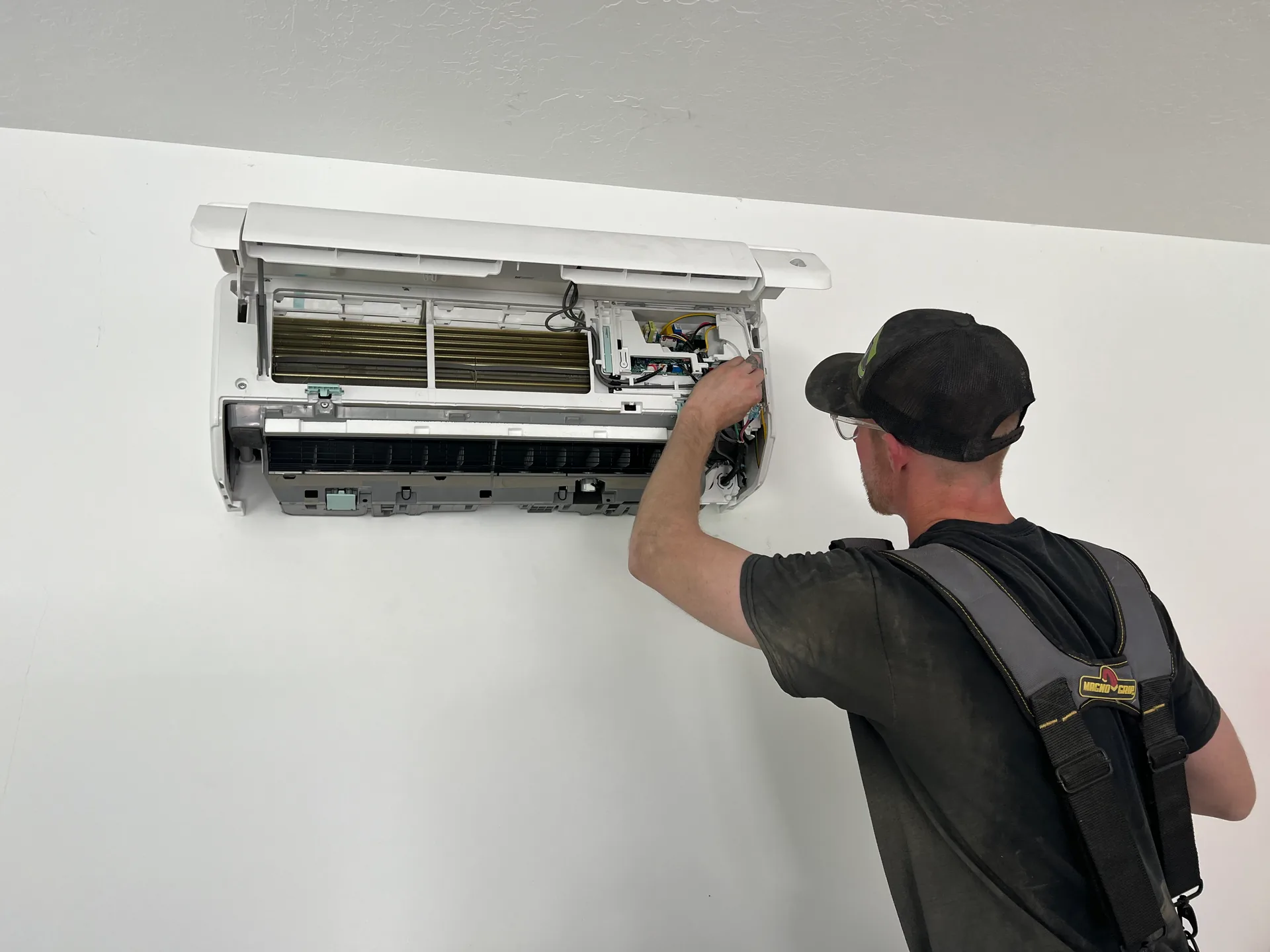 An All Around technician servicing a ductless mini-split head