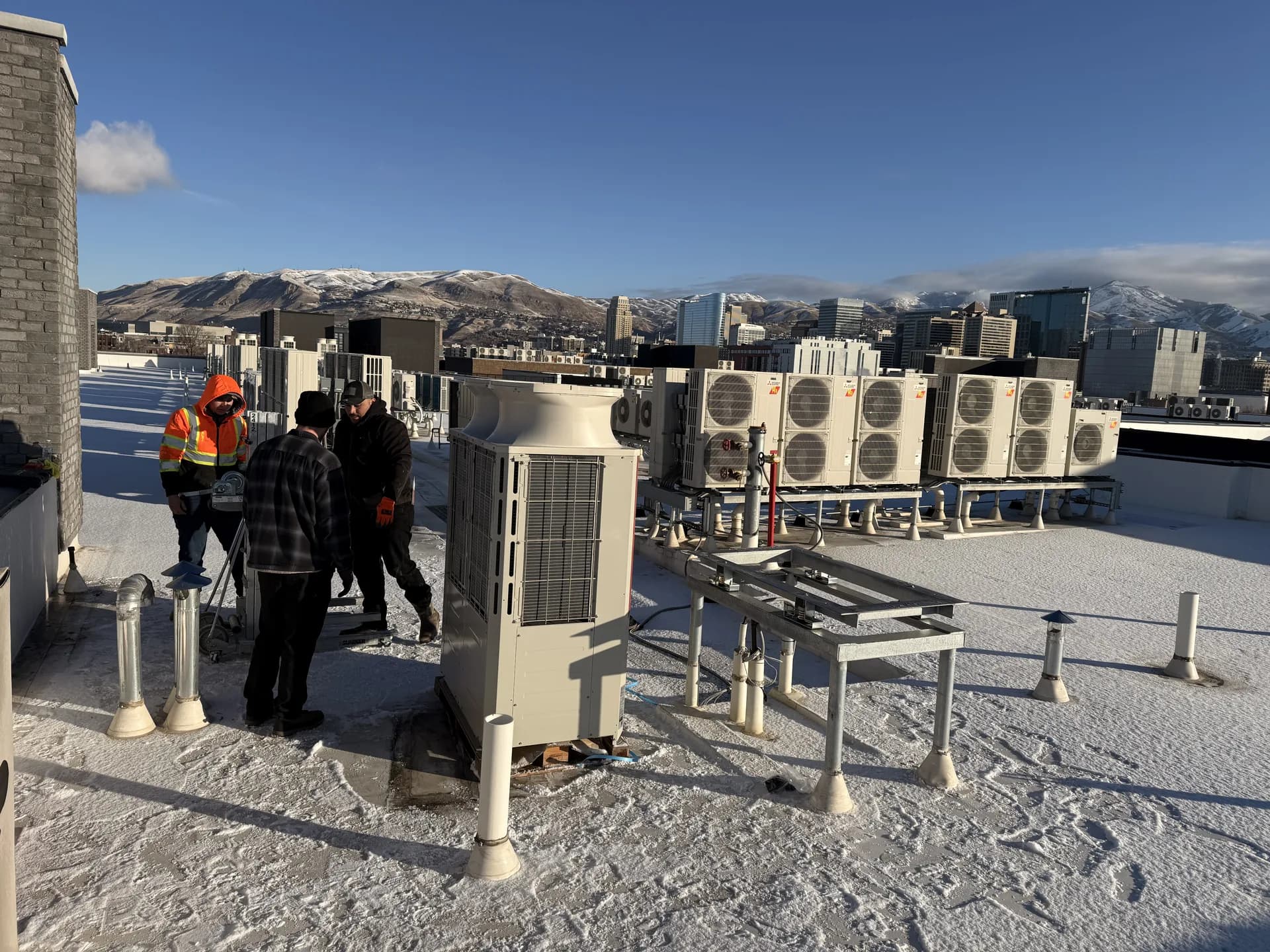 The crew setting rooftop units above the Salt Lake City skyline