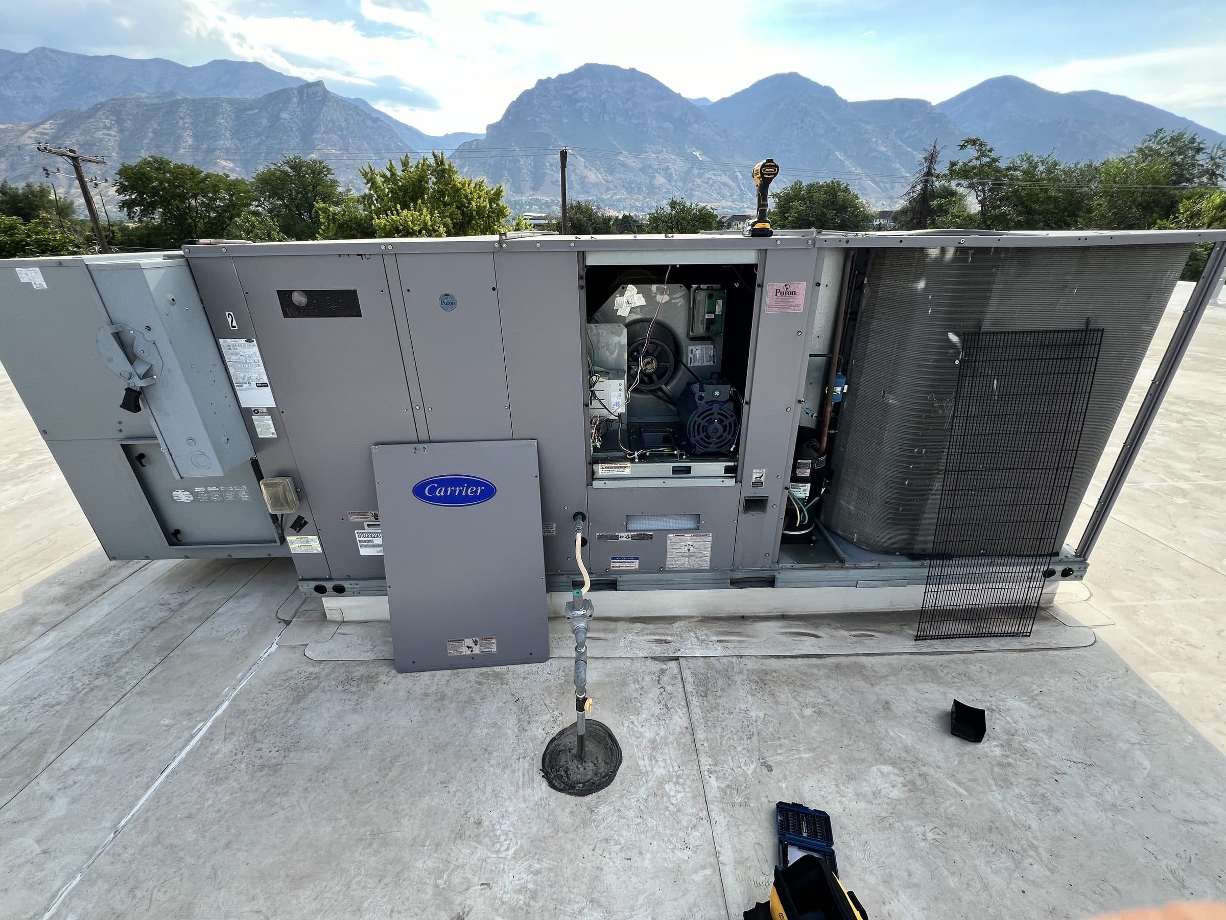 A rooftop packaged unit open for service, Wasatch range behind