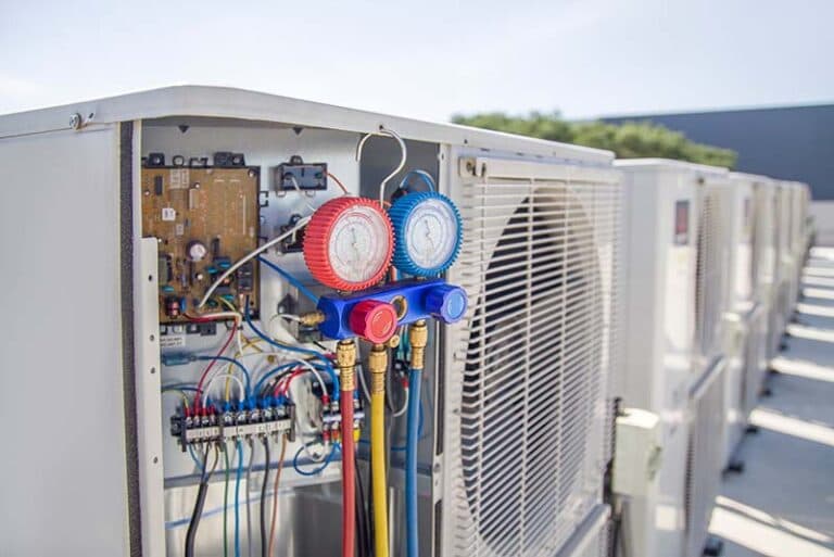 Refrigerant gauges connected to a commercial rooftop HVAC unit during maintenance—highlighting system compatibility checks ahead of the R-454B refrigerant transition.